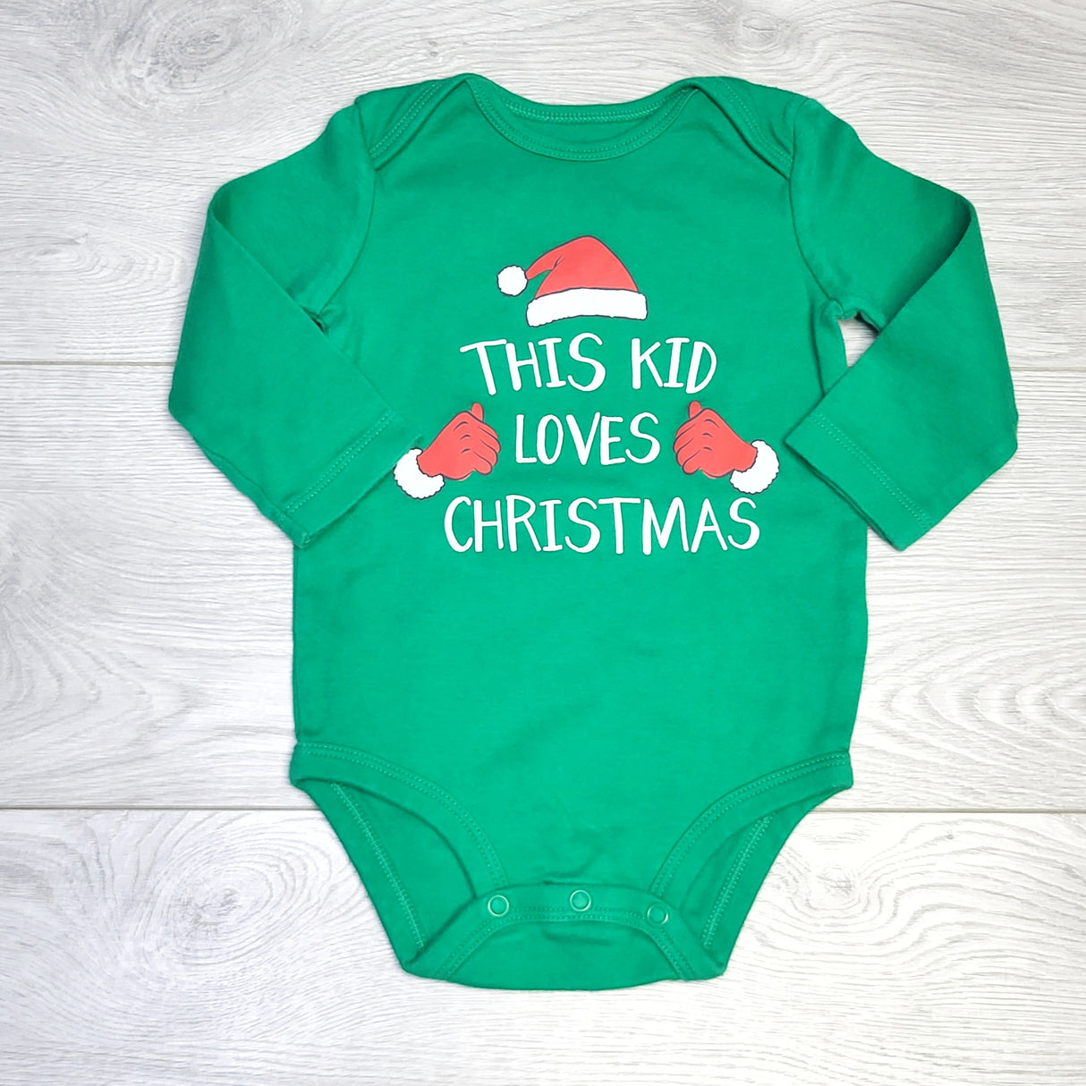 KJHN1 - Carters green "This Kid Loves Christmas" bodysuit. Size 12 months