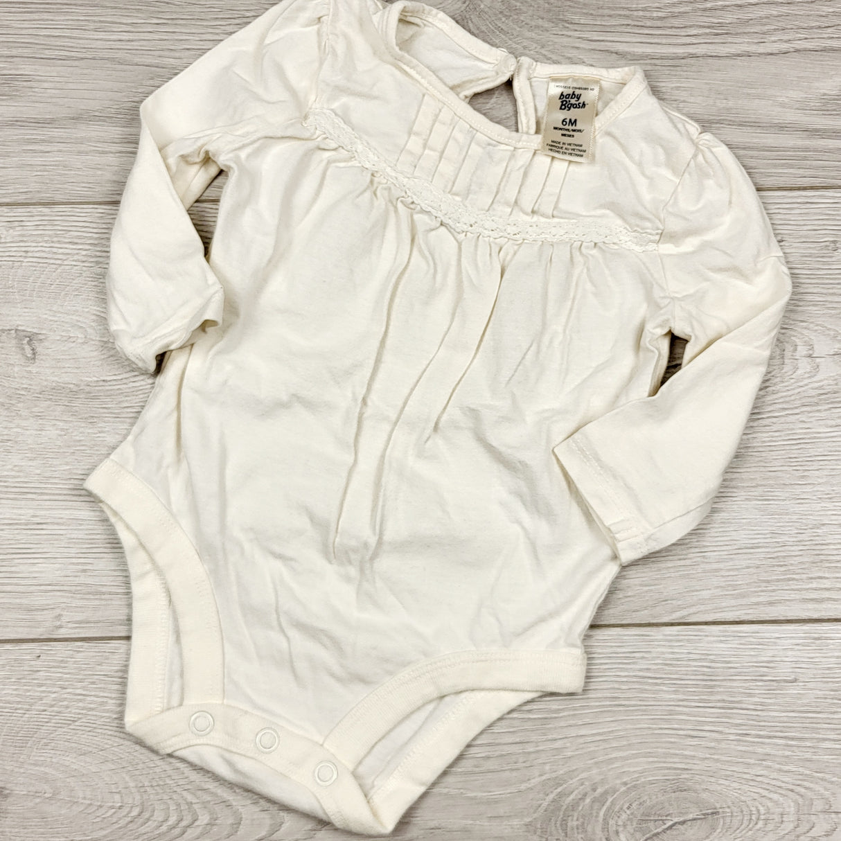 ECRS4 - Oshkosh cream coloured bodysuit with pleats. Size 6 months