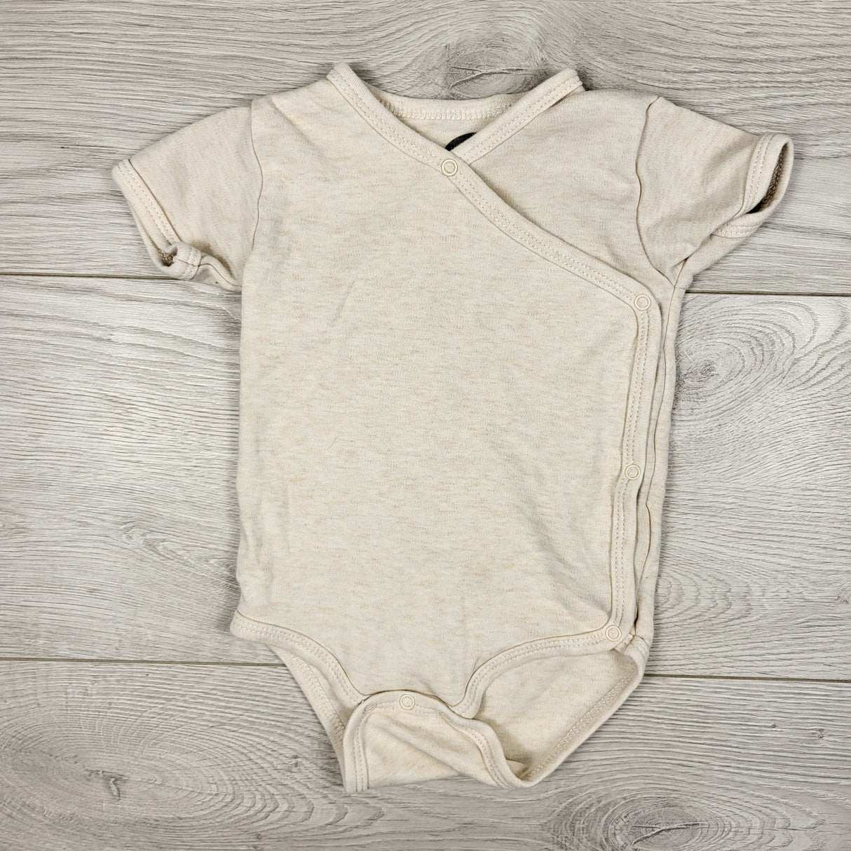 The Littlest beige organic cotton wrap style bodysuit. Size 3-6 months