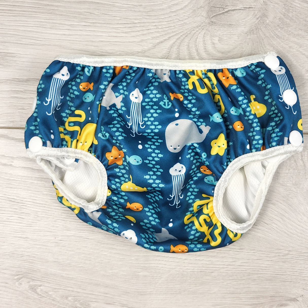 Bumkins teal reusable swim diaper with water theme. Size medium