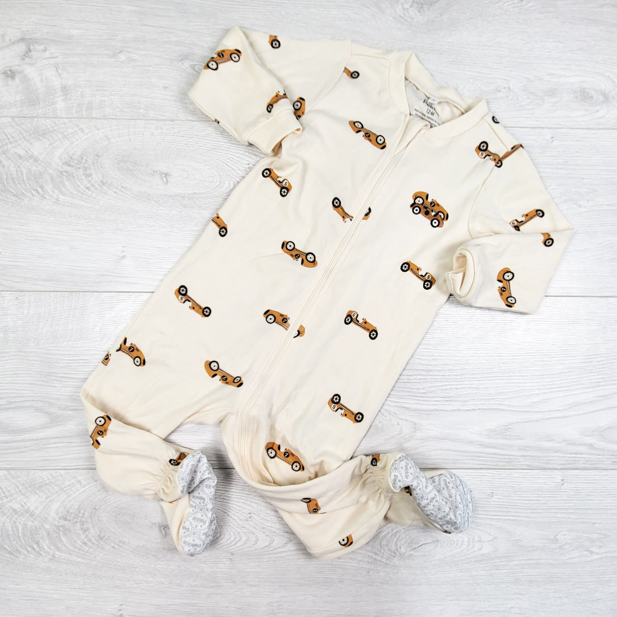 Pekkle cream coloured zippered sleeper with race cars. Size 12 months