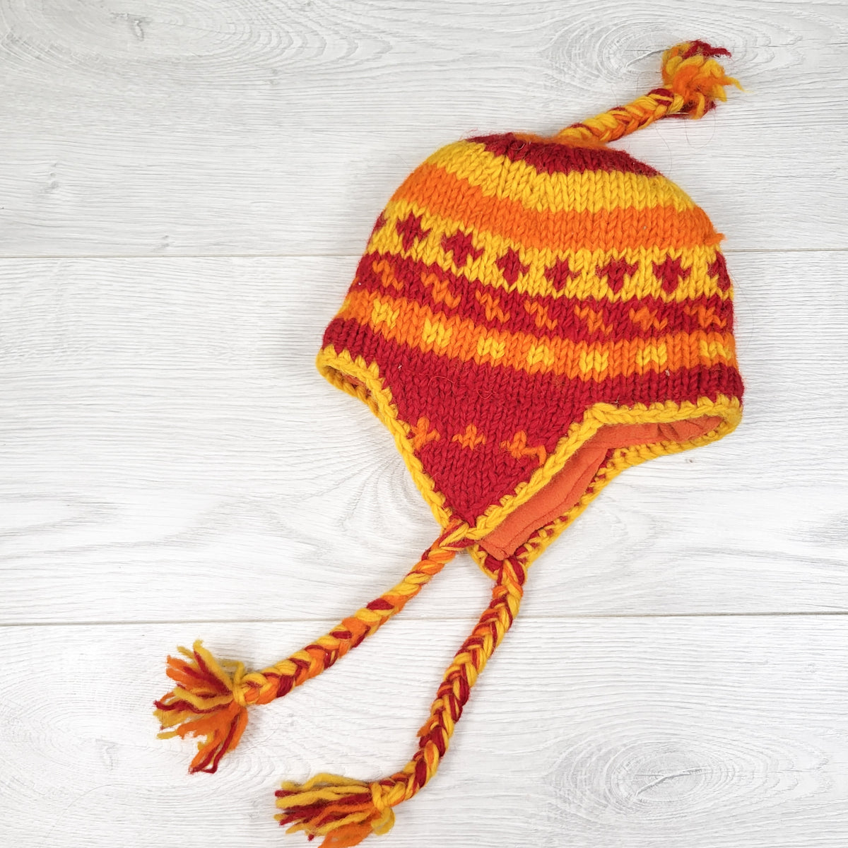 Handmade fleece lined ear flap wool toque. Made in Nepal.  Infant sized
