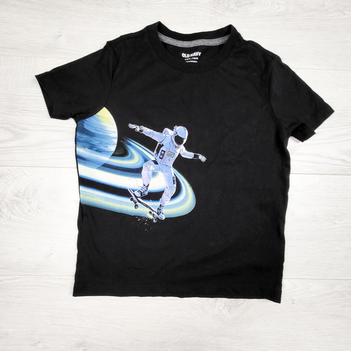 Old Navy black t-shirt with skateboarding astronaut. Size 6/7